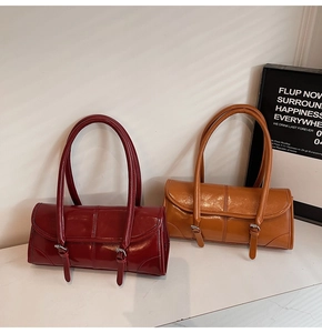 Detailed macro view of glossy burgundy and caramel leather bags with elegant silver buckles