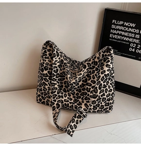 Detail of leopard print tote featuring thick fabric texture and silver metal buckle