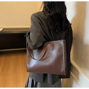 Macro view of a large dark brown vintage tote bag in matte leather for daily commute