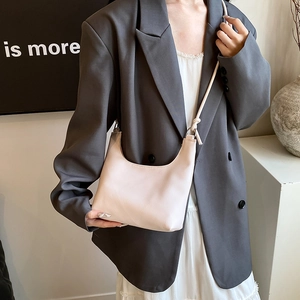 Minimalist beige half-moon crossbody bag with knotted strap and lychee texture