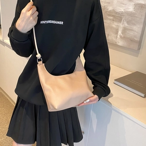 Minimalist beige moon shaped hobo bag made of pebble leather with shoulder strap