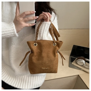 Brown suede bucket bag with gold chain strap and drawstring closure for stylish commuting