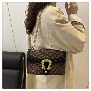 Detail of monogram M print bag with vintage gold ornate buckle and chain strap