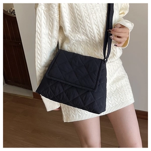 Close-up of black quilted nylon crossbody bag with diamond stitching and adjustable strap