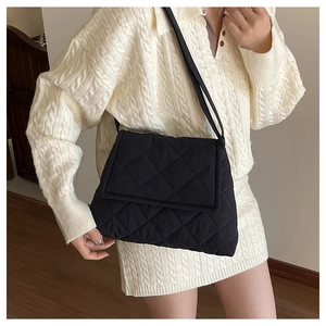 Close-up of black quilted nylon crossbody bag showing diamond stitching and flap texture