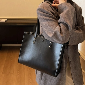 Classic black faux leather tote bag for women with gold rivet details and long straps