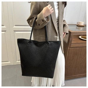 Close-up of black woven tote bag texture with long straps for versatile daily commute