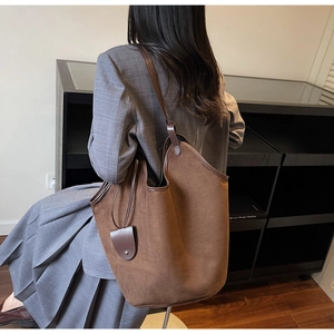 Detail of dark brown suede tote bag showing large capacity and minimalist retro design
