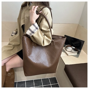 Brown woven leather tote bag shown with an autumn trench coat for professional commuting