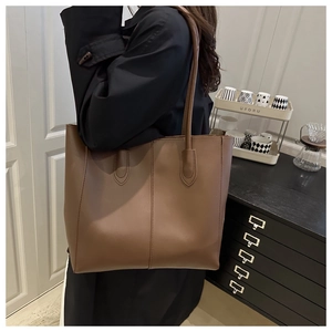 Detail of reinforced shoulder strap stitching on large brown leather tote bag