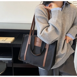 Detail of canvas tote bag with brown leather trim and versatile dual handles