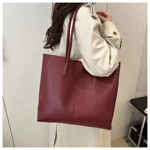 Detail of burgundy PU leather tote bag with vertical stitching and long shoulder straps