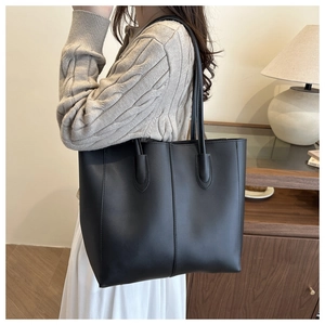 Détail du grand sac cabas en cuir noir montrant les poignées renforcées à l'épaule