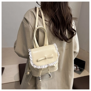 Creamy mini backpack with lace trim and bow detail shown on model for size reference