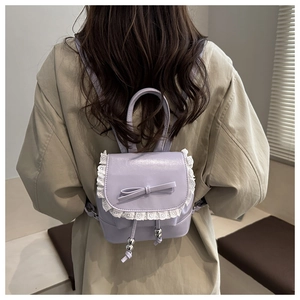 Close-up of lavender mini backpack featuring white lace trim and bow knot detail