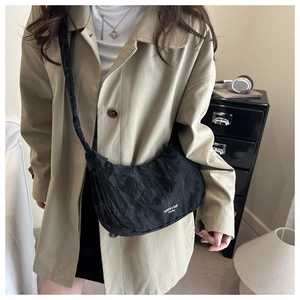 Detail of black nylon pleated cloud bag featuring Fashion & Bags logo and crossbody strap