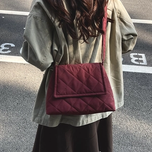 Burgundy quilted nylon crossbody bag with diamond stitch pattern and fabric strap