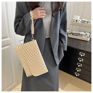 Detail of retro monogram patterned envelope clutch with detachable wrist strap and metal hook