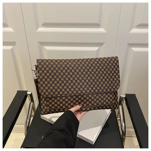 Close-up of vintage geometric pattern on brown envelope clutch bag with metal ring