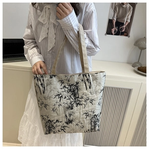 Close-up of a white tote bag featuring traditional Chinese bamboo embroidery and wide handles