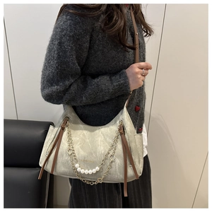 Vue détaillée du sac à bandoulière vert avec chaîne en métal et perles décoratives
