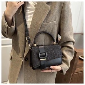Detail of black sequined crossbody bag with square buckle on khaki blazer outfit