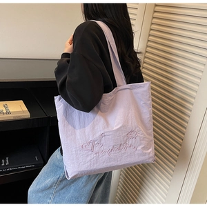 Détail du sac cabas lilas avec broderie de cœur rose et texture de tissu durable