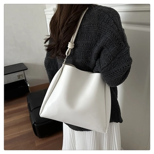 Rear view of a minimalist white PU leather tote bag with knotted shoulder strap detail