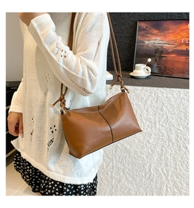 Brown leather crossbody bag with knot strap detail and vertical seam styling
