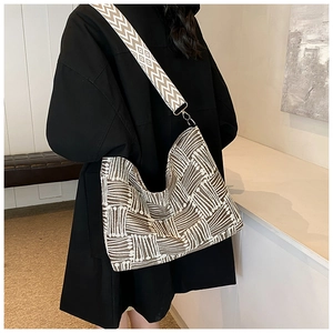 Detail of woven geometric stripe shoulder bag in brown and cream with wide strap