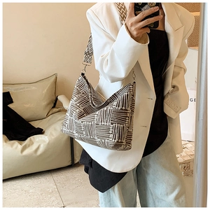 Detail of hobo bag with geometric woven texture and wide patterned shoulder strap