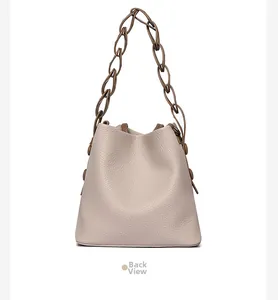 Back view of beige bucket bag showing litchi texture and dark brown chain handle