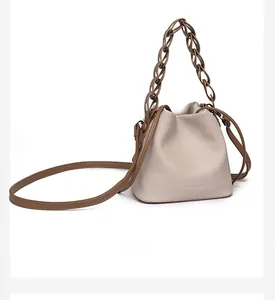 Detail of beige lychee leather bucket bag with brown resin chain handle and drawstring