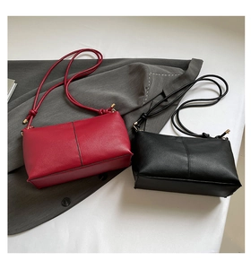 Detail of red and black lychee grain faux leather shoulder bags with gold hardware