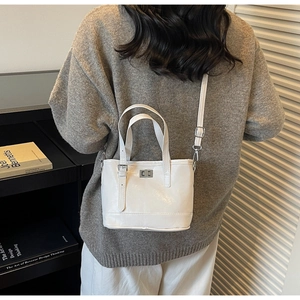 Détail du sac à main blanc en cuir avec fermoir pivotant argenté et bandoulière réglable