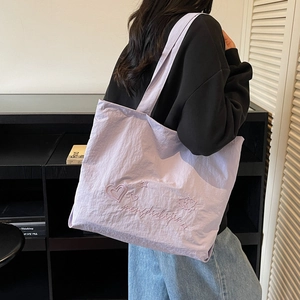 Minimalist lavender tote bag with embroidery shown on model in a modern room