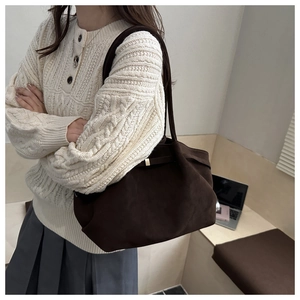 Detail of dark brown matte suede shoulder bag with thin straps for autumn workwear style