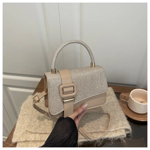 Detail der modischen kleinen Tasche mit silberner Glitzerklappe und beigem Lederkorpus