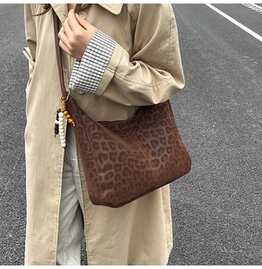 Detail of leopard print tote bag with bohemian wooden beads on a stylish crossbody strap