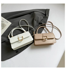 Detail view of stylish crossbody bags with golden D-shaped buckles in white and beige