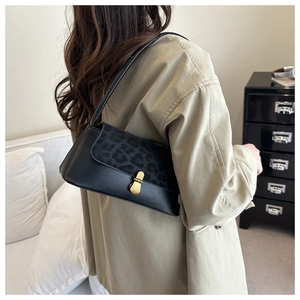 Detailed close-up of retro baguette bag featuring leopard print flap and golden metal lock