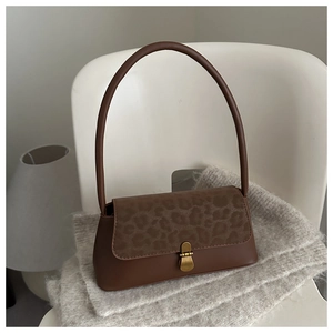 Détail du rabat léopard et du fermoir en métal doré vintage sur le sac marron