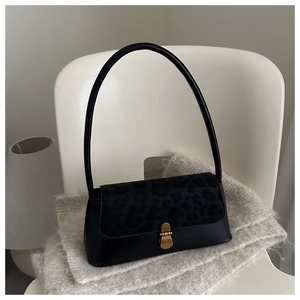 Détail du sac baguette noir avec rabat à motif léopard et fermoir doré en métal rétro