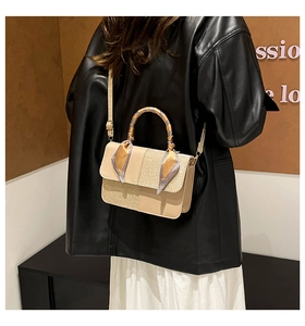 Detail of beige crossbody bag with glitter fabric panels and silk scarf wrapped handle