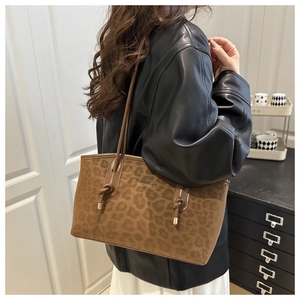 Detail of a brown leopard print tote bag featuring a textured faux suede finish