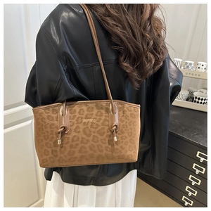Close-up of leopard print tote bag in brown suede with slim leather shoulder straps