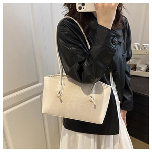 Close-up of creamy white leopard print tote bag with unique knotted strap and metal tip
