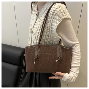 Detail view of large brown faux suede tote with leopard print and thin shoulder straps