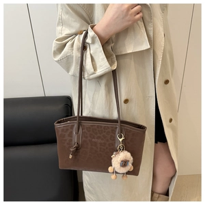 Detail of vintage leopard print tote bag with plush charm and long leather shoulder straps