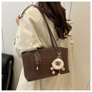 Detail of coffee brown leopard print tote bag with soft plush sheep keychain accessory